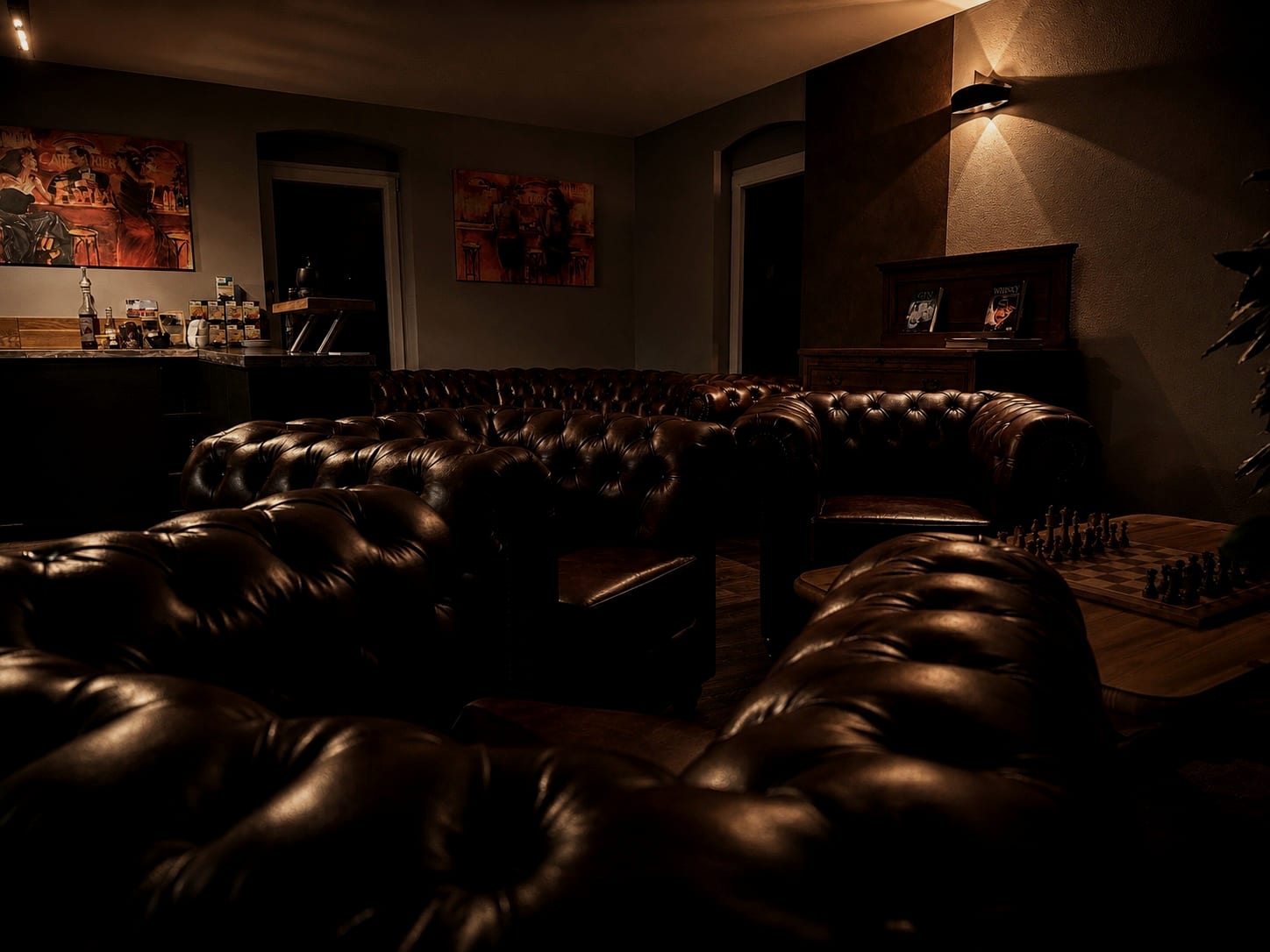 Ruhige Lounge im ANSATSU Atelier mit dunklen Ledersesseln und warmem Licht